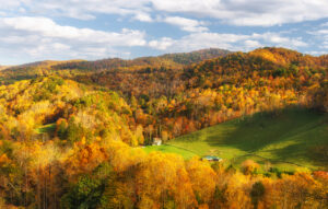 Banner Elk during the fall, rolling hills with trees cast in gold, red, and orange