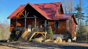 a Boone NC home for sale, a red cabin with steps leading up to the porch