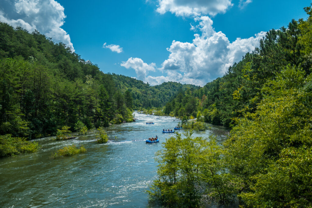 several,groups,of,people,in,large,rafts,going,whitewater,rafting